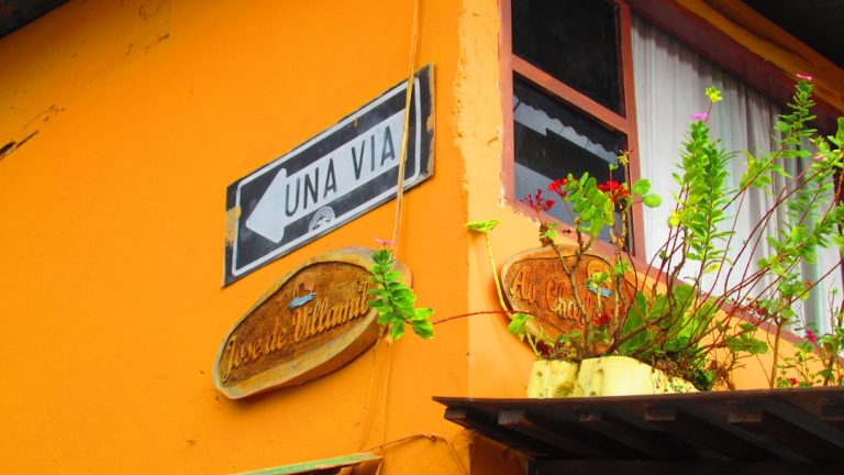 a street sign mounted to the side of a yellow building