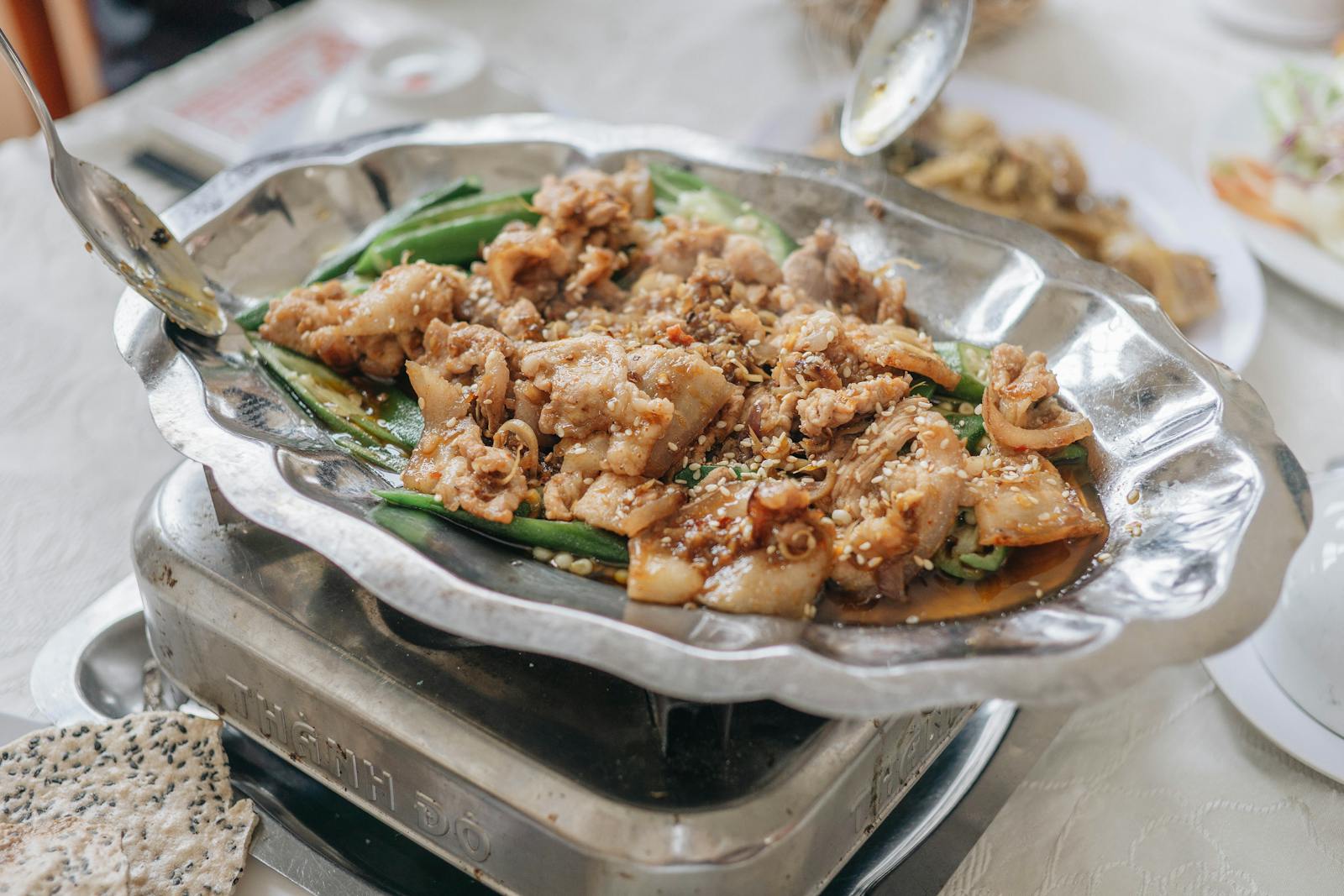 A delicious Chinese stir fry pork dish served on a decorative metal tray, perfect for culinary presentations.