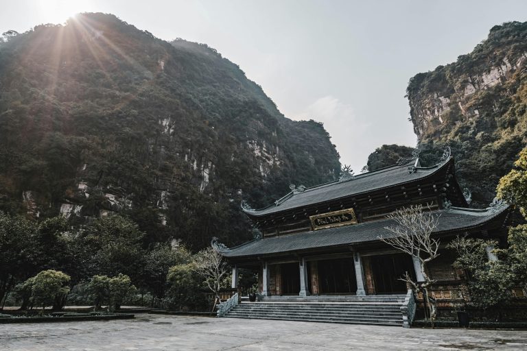 Breathtaking view of a Buddhist temple amidst stunning limestone mountains in Ninh Bình.