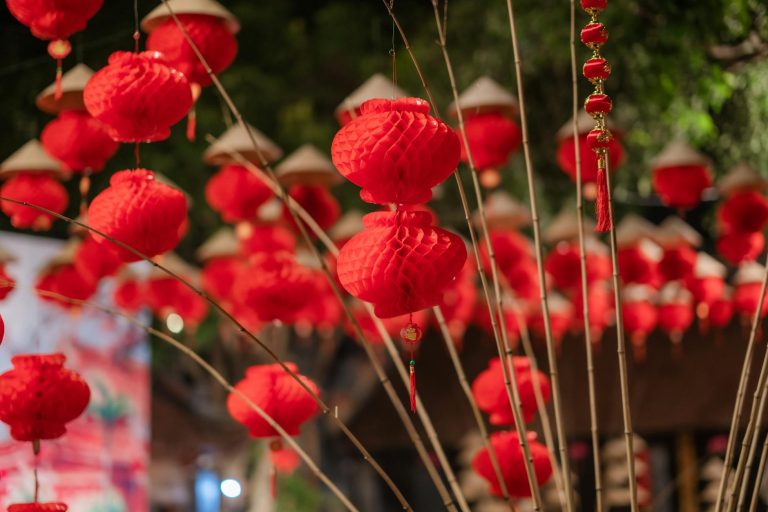 Enchanting red paper lanterns illuminate an outdoor night festival, creating a festive atmosphere.